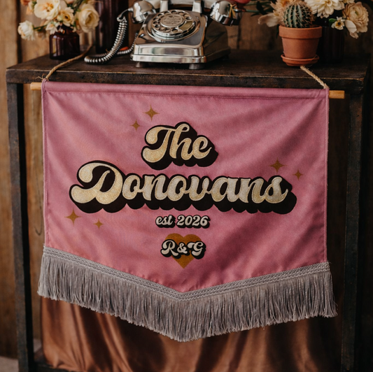 Decorative setup with flowers, vintage phone, and 'The Donovans' banner on a wooden table.